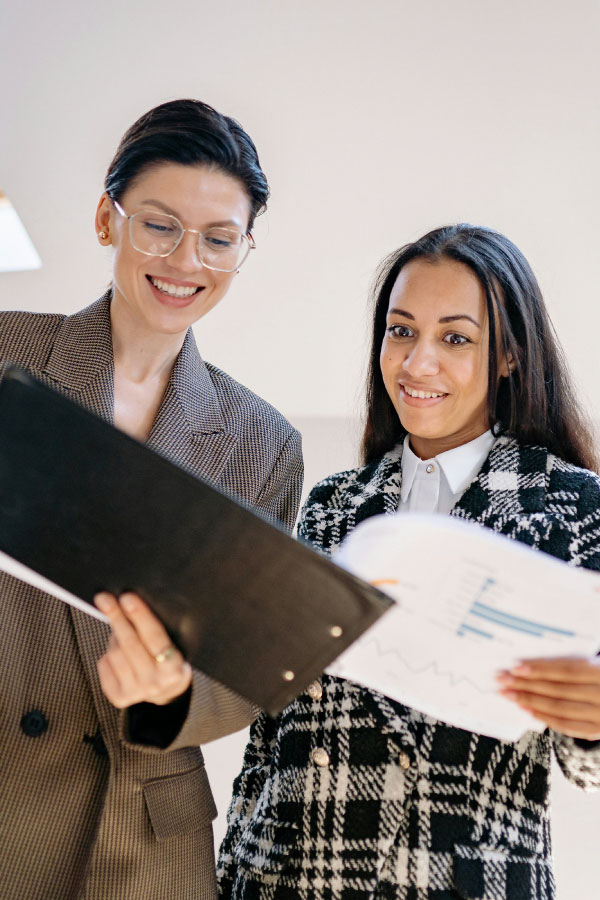 Dos agentes de Ireka revisando documentación y asesorando legalmente sobre servicios inmobiliarios
